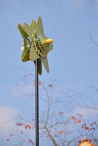 Close-up of star shaped metallic object against blue sky