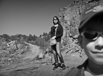 Full length of friends standing on landscape against clear sky