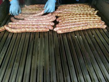 High angle view of person grilling asado sausages on barbecue