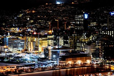Illuminated cityscape against sky at night