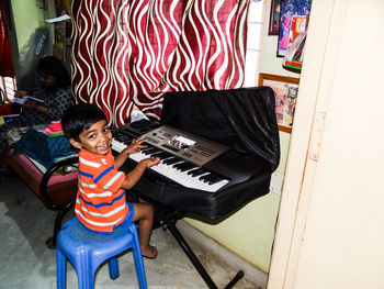 Portrait of smiling boy playing piano at home