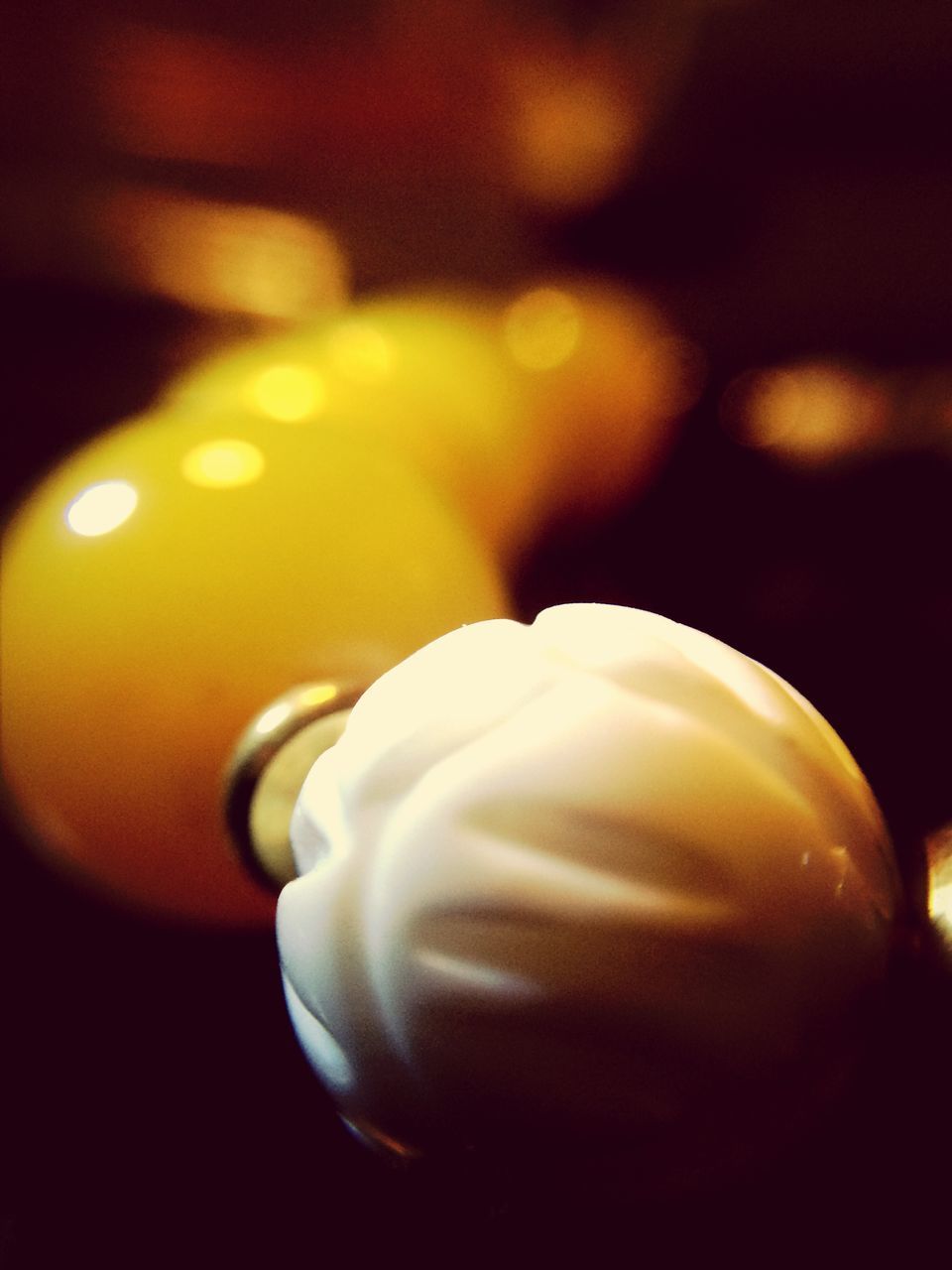 close-up, indoors, focus on foreground, still life, single object, selective focus, no people, table, shiny, black background, candle, home interior, sphere, decoration, reflection, fragility, white color, lighting equipment, illuminated, metal