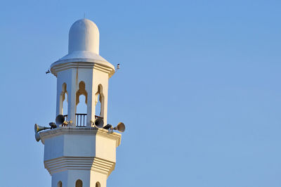Low angle view of lighthouse against clear blue sky
