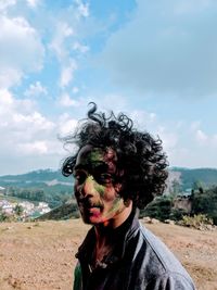 Portrait of man face covered with powder paint against sky