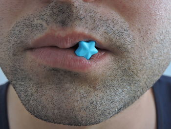 Close-up of man having blue candies