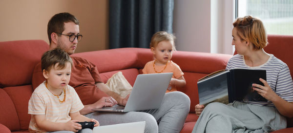 Big happy family watching movies playing games on laptop. mother father kids spending time with