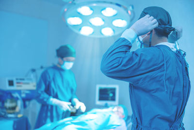 In the operating room of a hospital, a group of surgeons are performing surgery.