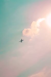 Low angle view of airplane flying against sky during sunset