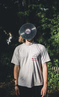 Rear view of boy standing against trees