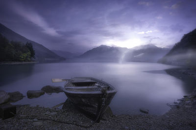 Scenic view of lake by mountains against sky