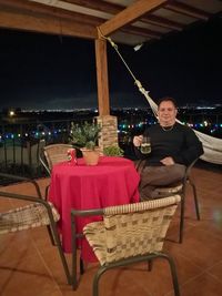 Portrait of a man with woman sitting on table at night