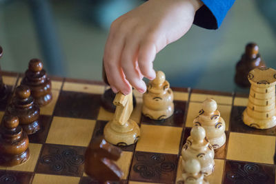 Cropped hand of child playing chess