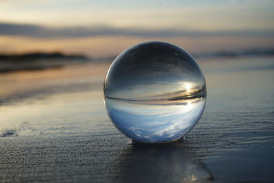 Close-up of crystal ball on beach