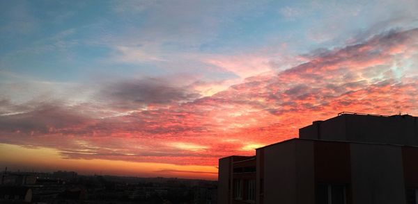 Modern cityscape against sky during sunset