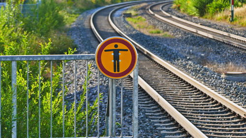 Road sign by railroad tracks