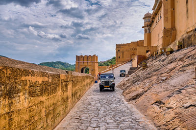 Road amidst buildings in city against sky