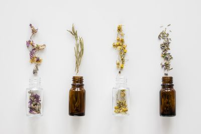 Low angle view of bottles on glass against white background