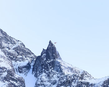 Low angle view of snowcapped mountain against clear sky