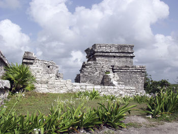 Low angle view of old building against cloudy sky