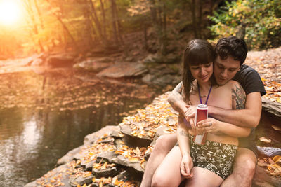 Young couple sitting near a stream