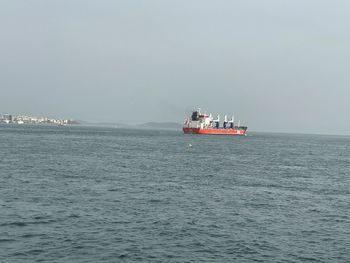 Ship sailing on sea against clear sky