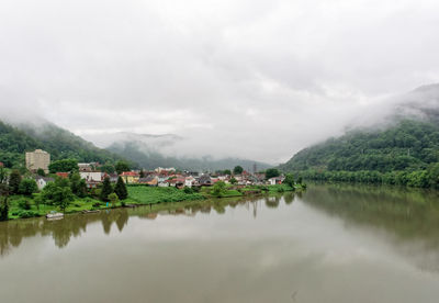 Scenic view of river by mountains against sky