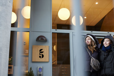 Female couple standing in front of apartment building