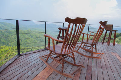 Empty chairs and tables against sky