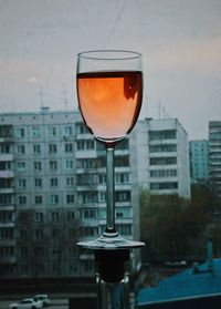 Close-up of beer in glass building against sky