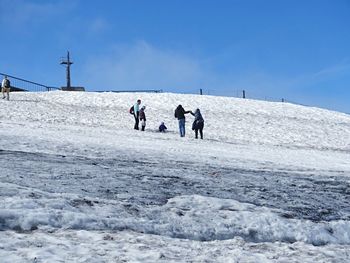 People on mountain against clear sky