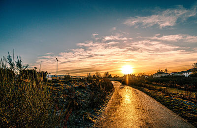 Scenic view of path against sky at sunset