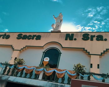 Low angle view of statue against building against sky