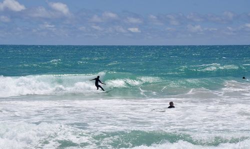 Man surfing in sea against sky