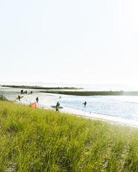 People at beach against clear sky