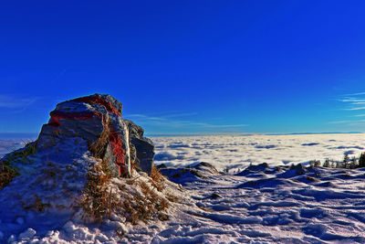Scenic view of snowcapped landscape against blue sky
