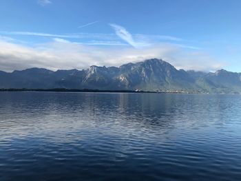 Scenic view of lake by mountains against sky