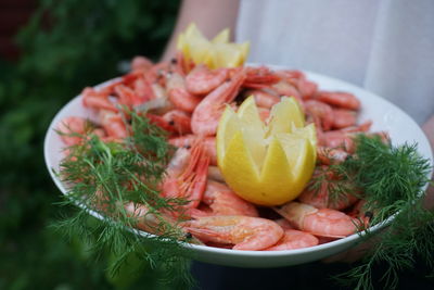 Midsection of man holding seafood in plate