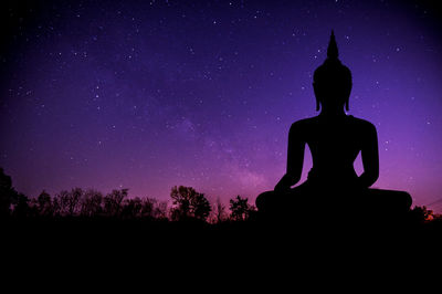 Low angle view of silhouette statue against sky at night