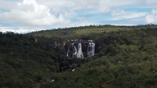 Scenic view of waterfall against sky