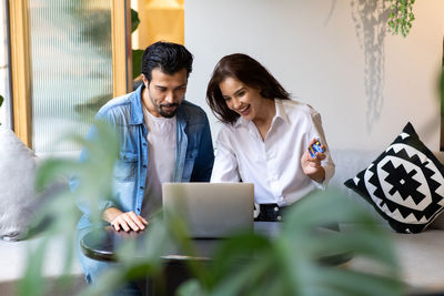 Colleagues using laptop at home