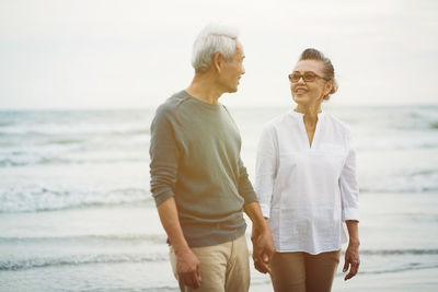 Rear view of couple standing at beach