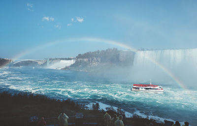 Panoramic view of people sailing on sea against sky