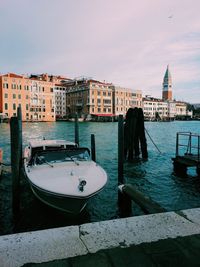 Boats moored on sea against buildings in city