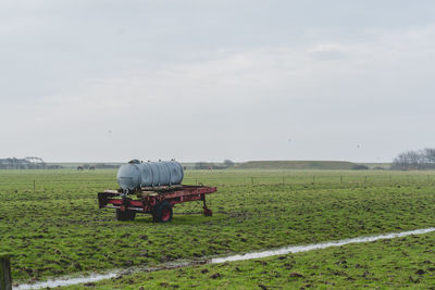 Men working on agricultural field against sky