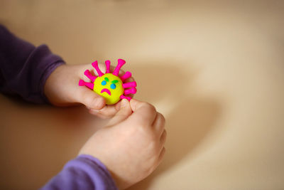 Close-up of hand holding pink flower