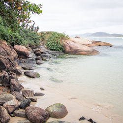 Rocks by sea against sky