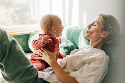 Side view of mother and daughter at home