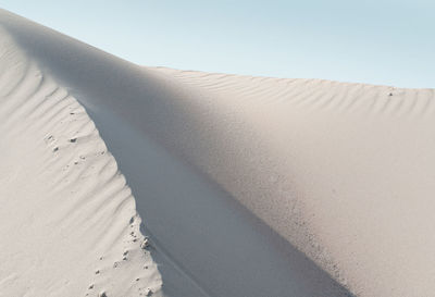 Sand dunes against clear sky