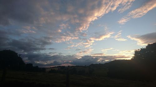 Scenic view of dramatic sky over silhouette trees