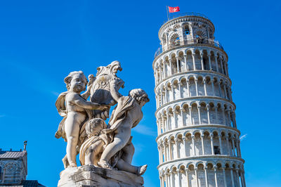 Low angle view of statue of building against blue sky